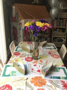 Wellie Wisher Birthday Party Table Decorations with flower tablecloth, fresh flowers and crowns